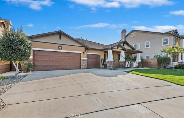 view of front of house with an attached garage, a front yard, concrete driveway, and stucco siding