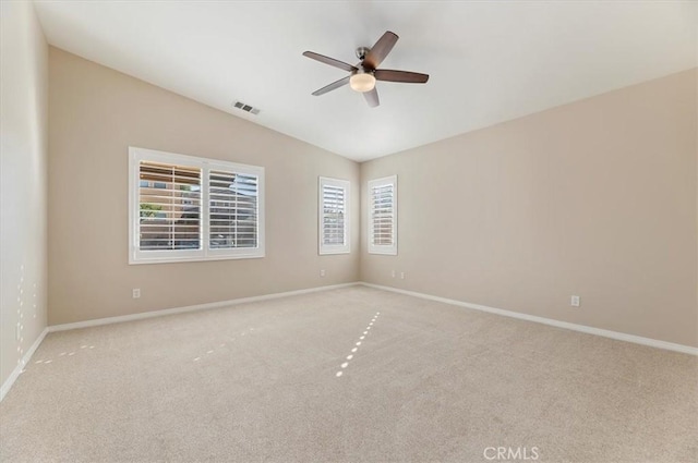 spare room featuring a ceiling fan, visible vents, vaulted ceiling, and carpet floors