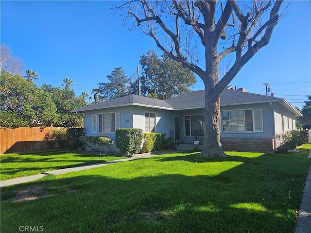 view of front facade featuring a front yard, fence, and stucco siding