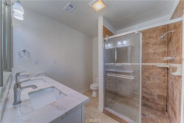 bathroom with toilet, a stall shower, a sink, and visible vents