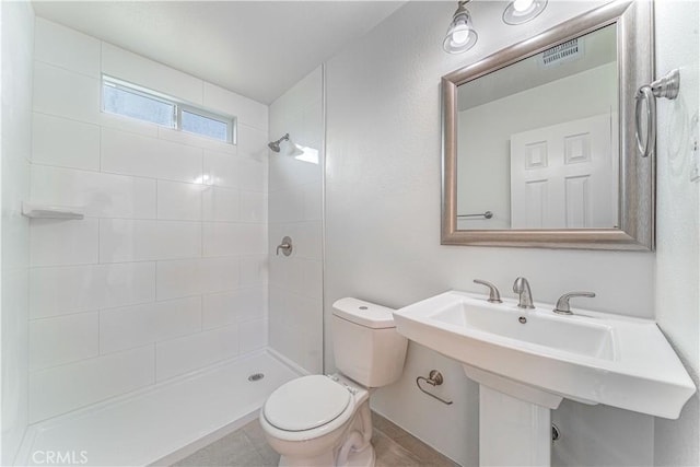 full bath featuring toilet, visible vents, and a tile shower