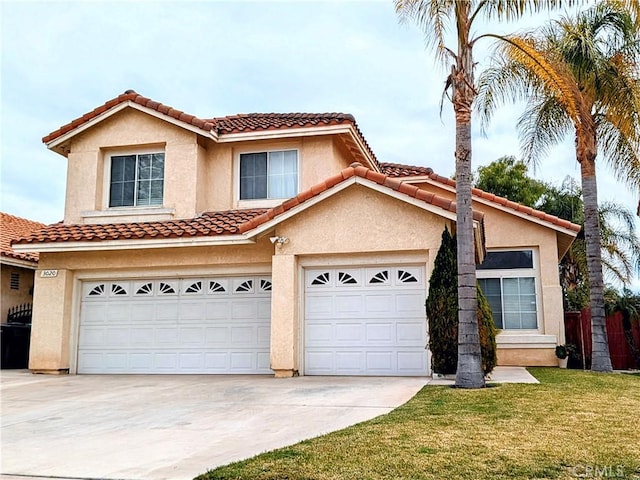 mediterranean / spanish-style house featuring a garage, driveway, a front lawn, and stucco siding