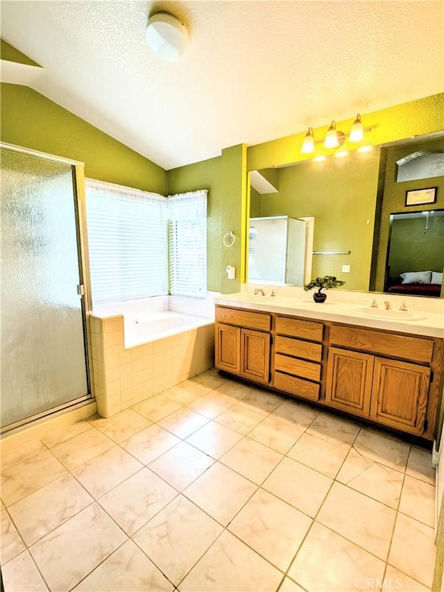 bathroom with lofted ceiling, a textured ceiling, a garden tub, a sink, and double vanity