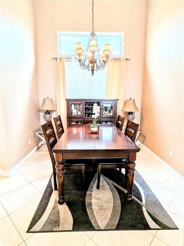 tiled dining room featuring a chandelier and baseboards