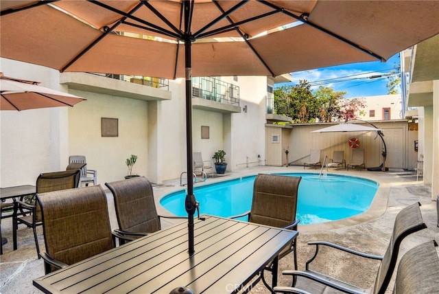 view of swimming pool with a fenced in pool, outdoor dining area, and a patio