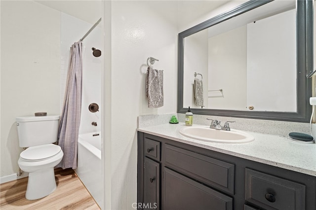 bathroom with vanity, wood finished floors, toilet, and shower / tub combo with curtain