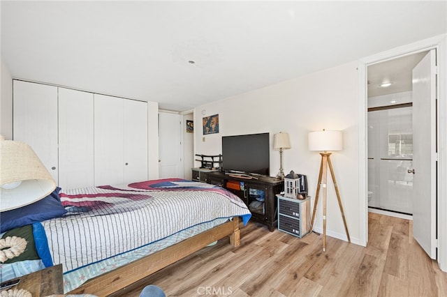 bedroom featuring ensuite bathroom, a closet, and light wood-style flooring