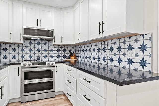 kitchen with appliances with stainless steel finishes, light wood-type flooring, white cabinets, and decorative backsplash