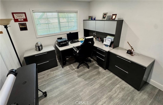 home office featuring light wood-type flooring and baseboards