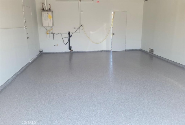 garage with baseboards and water heater