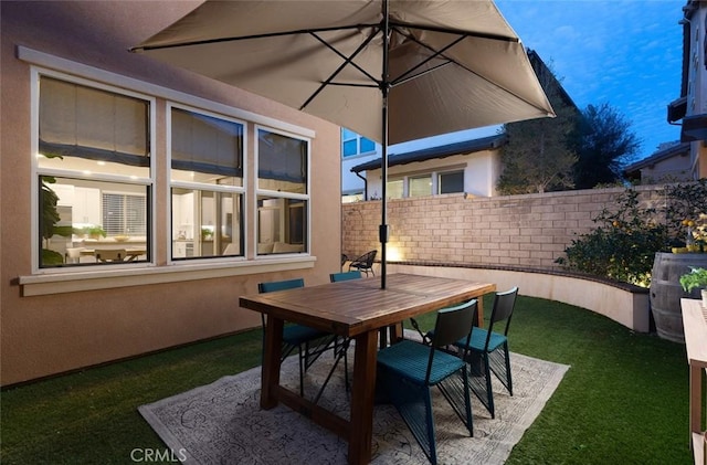 view of patio with outdoor dining space and fence