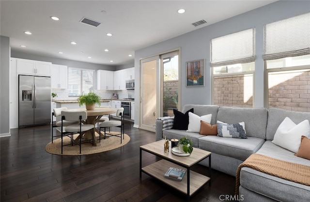 living area featuring recessed lighting, dark wood-style floors, and visible vents