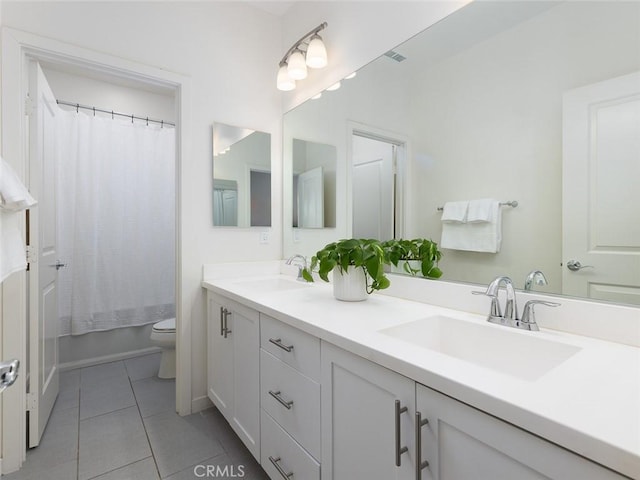 full bath featuring a sink, toilet, double vanity, and tile patterned floors