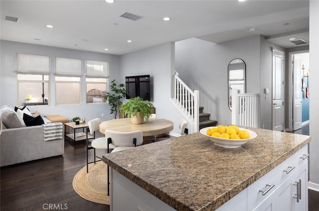 kitchen featuring dark wood-type flooring, white cabinets, recessed lighting, and visible vents