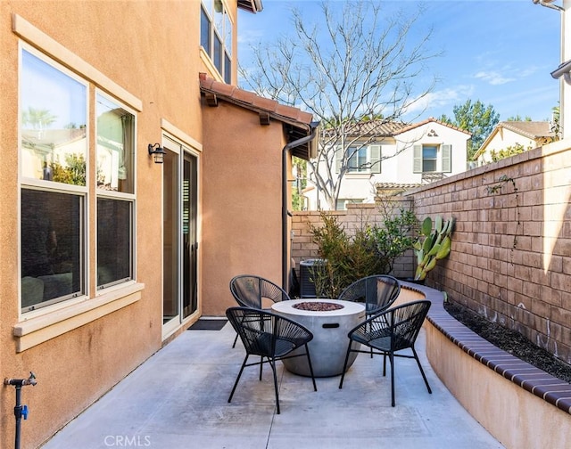 view of patio / terrace with an outdoor fire pit, central AC, and fence