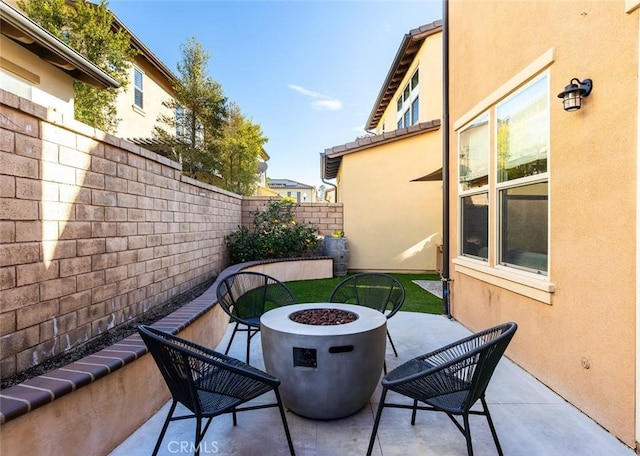 view of patio / terrace with a fire pit and fence