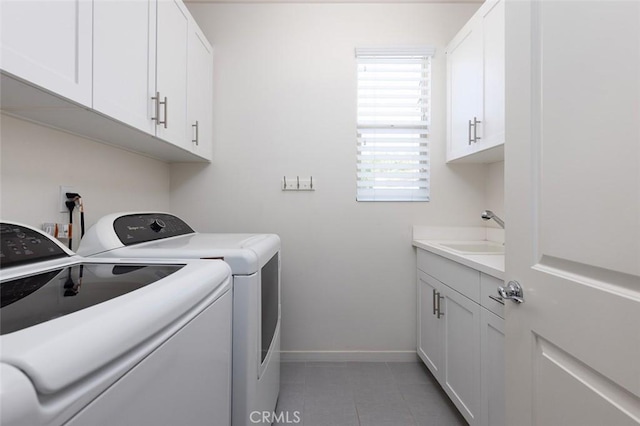 laundry room with baseboards, washing machine and dryer, light tile patterned floors, cabinet space, and a sink