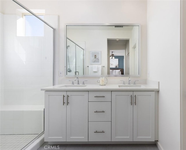 ensuite bathroom featuring a sink, ensuite bathroom, a stall shower, and double vanity