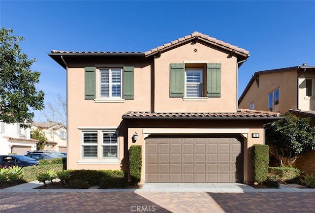 view of front of house featuring stucco siding, decorative driveway, and a garage