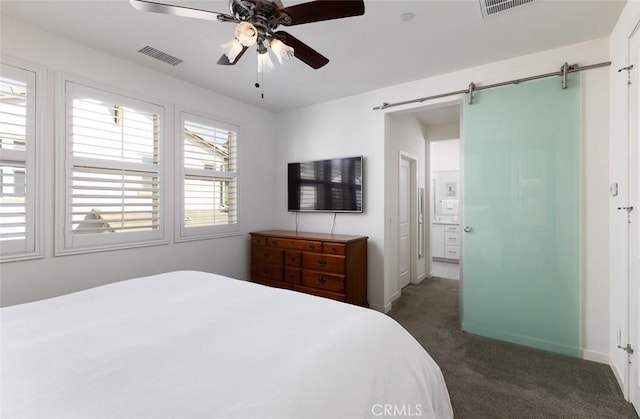 bedroom with a barn door, a ceiling fan, visible vents, and carpet flooring