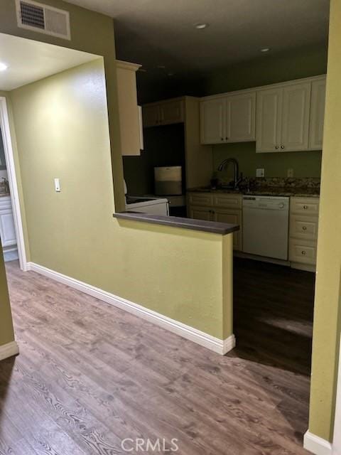 kitchen with dark countertops, visible vents, dark wood-style flooring, and dishwasher