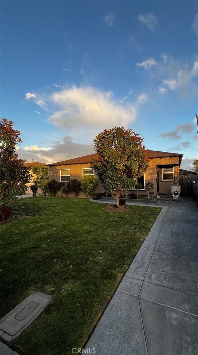 view of front facade with a front lawn and stucco siding