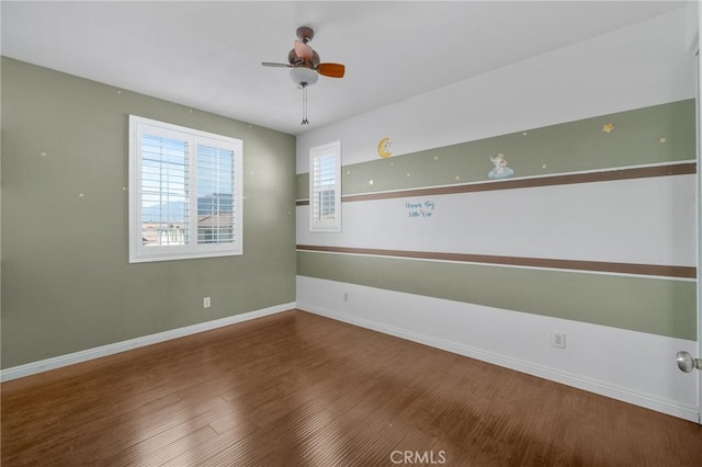 empty room featuring ceiling fan, wood finished floors, and baseboards