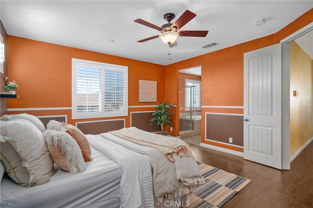 bedroom with ceiling fan, multiple windows, visible vents, and ensuite bathroom