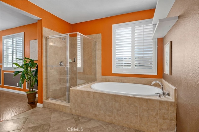 bathroom featuring tile patterned flooring, a shower stall, and a bath