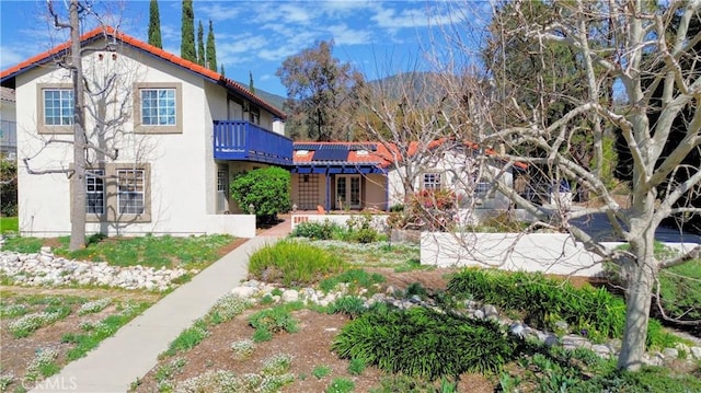 view of front of house with a balcony and stucco siding