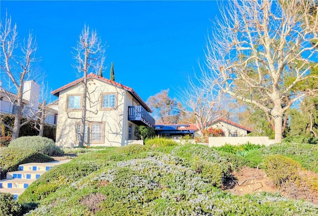 exterior space with a tiled roof and stucco siding