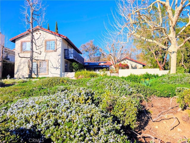 view of home's exterior with a tile roof and stucco siding