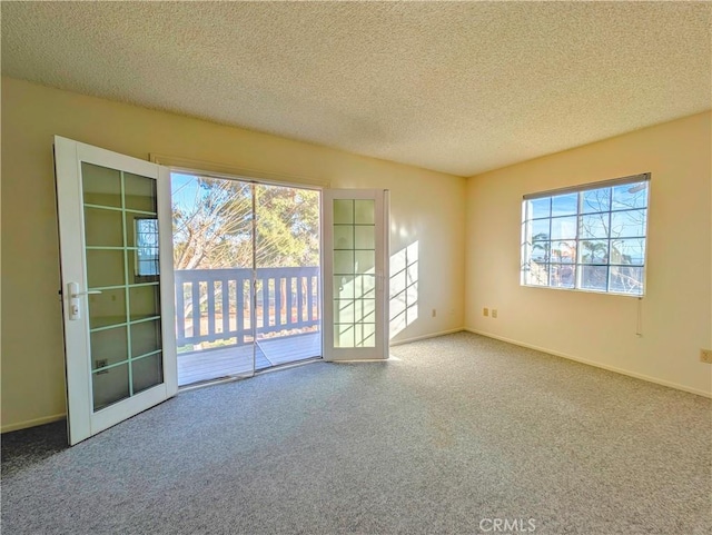 unfurnished room with carpet floors, a textured ceiling, and baseboards