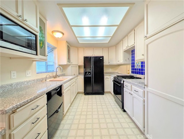 kitchen featuring a sink, black appliances, light countertops, and light floors