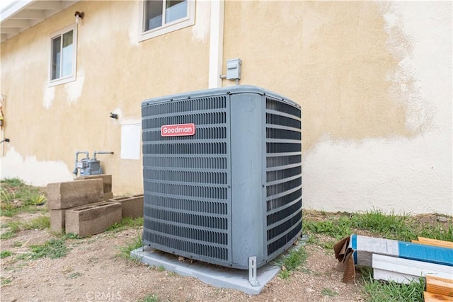 details with gas meter, central AC, and stucco siding