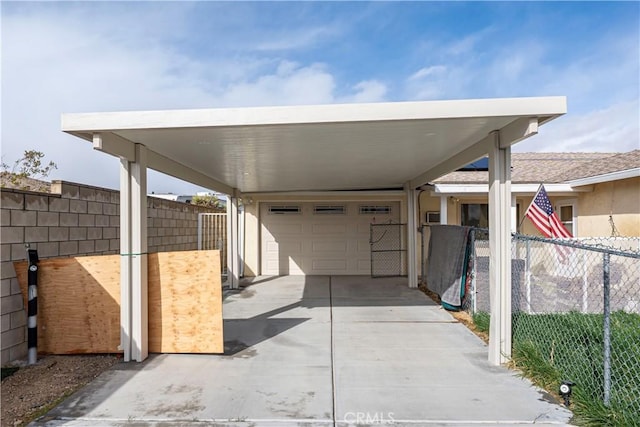 view of patio featuring an attached carport, driveway, a garage, and fence