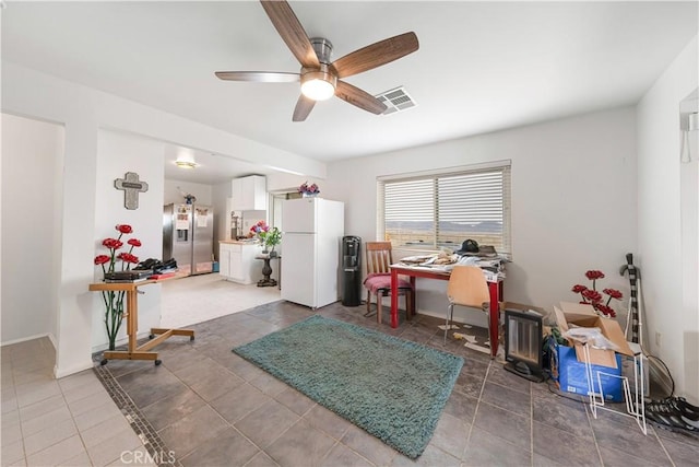 office area with tile patterned floors, a ceiling fan, visible vents, and baseboards