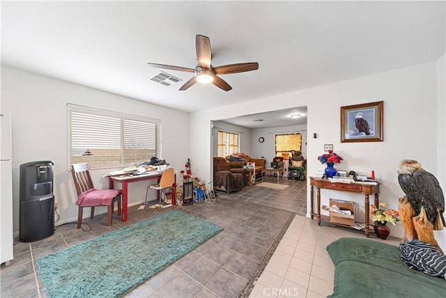 living room with tile patterned flooring, visible vents, and a ceiling fan