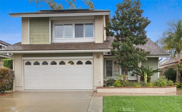 view of front of house featuring driveway, an attached garage, and stucco siding