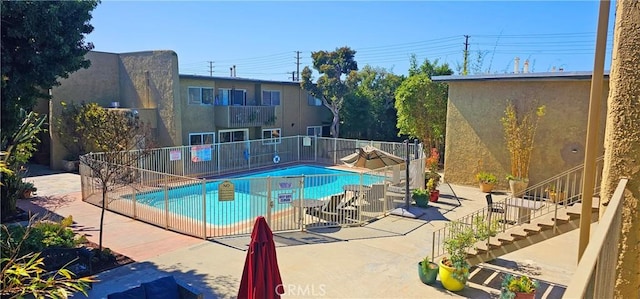 pool featuring stairs, a patio, and fence