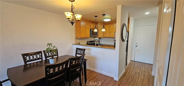 dining space featuring baseboards and light wood finished floors