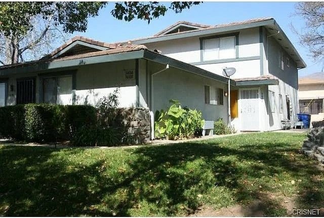 view of home's exterior with stucco siding and a yard