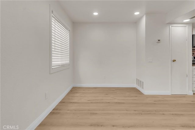 unfurnished room with light wood finished floors, recessed lighting, visible vents, and baseboards