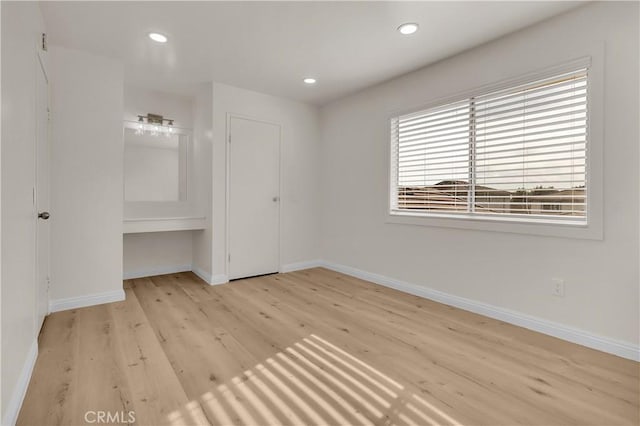 unfurnished bedroom with recessed lighting, wood finished floors, and baseboards