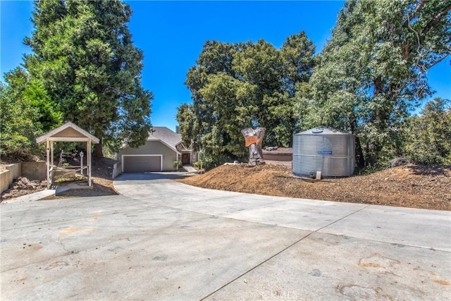 view of yard featuring a garage and concrete driveway