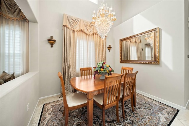 tiled dining space with baseboards and a chandelier