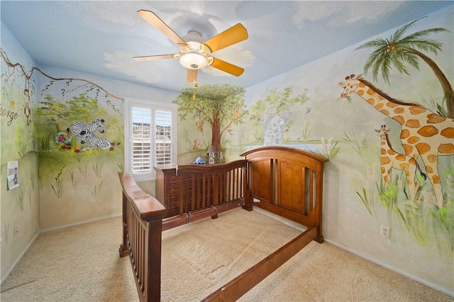 bedroom featuring light colored carpet, ceiling fan, a textured ceiling, and baseboards