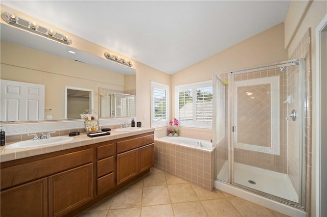 full bath with lofted ceiling, a stall shower, a sink, and a bath