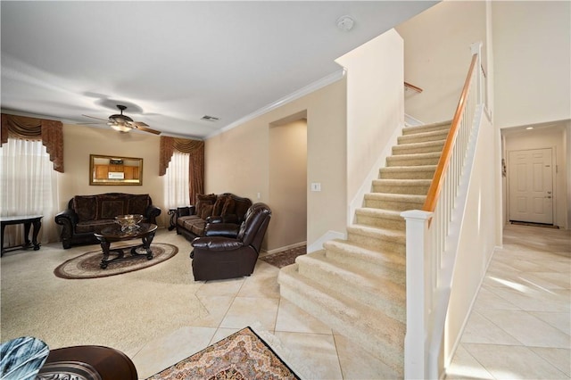 living room with light tile patterned floors, a ceiling fan, baseboards, stairway, and crown molding