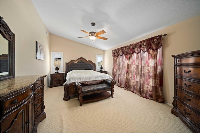 bedroom with vaulted ceiling, visible vents, light carpet, and a ceiling fan